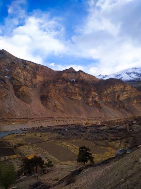 Gökyüzü ve bulutlarla muhteşem bir dağ manzarası.