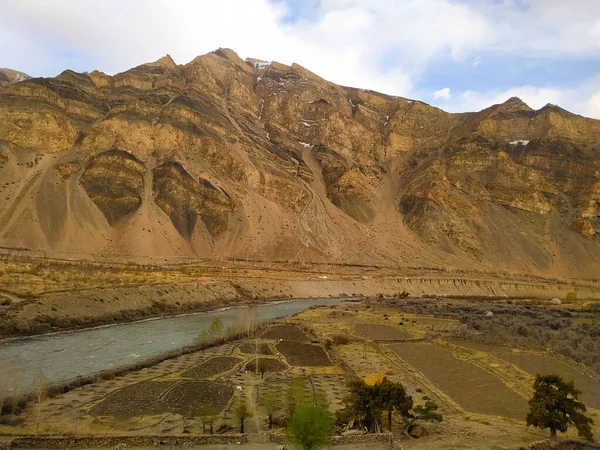 Dağlardaki ağaçlar ve tarlalarla akan nehrin muhteşem manzarası.