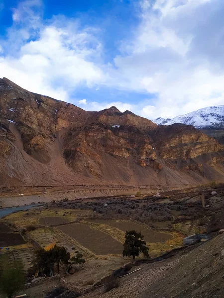 Gökyüzü ve bulutlarla muhteşem bir dağ manzarası.
