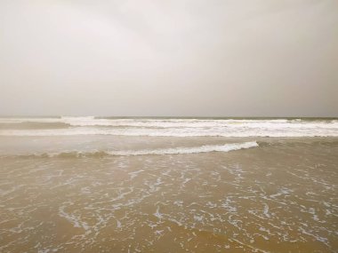 Sahilin arka planında kum dalgalarının inanılmaz görüntüsü