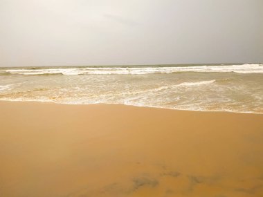 Dalgalar kumsalda kum ve deniz kabuğu parçalarıyla atıyor. Doğa arkaplan kavramı.