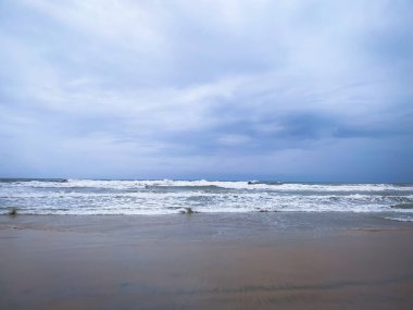 Bulutlu gökyüzü ile kumsalda yumuşak bir deniz dalgası