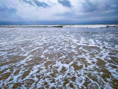 Clouds over beautiful waves on the beach