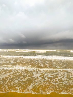 Kumsalda bulutlu gökyüzü ile güzel dalgalar