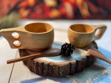 Ahşap bir tezgah var. Şöminenin yanındaki beyaz masada da kahve için tahta bardaklar var.