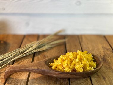 Meşe ağacından yapılmış bir masa. Üzerlerindeki kavanozları görebilirsiniz. Bir sürü mısır ve erişteli tahta kaşık.