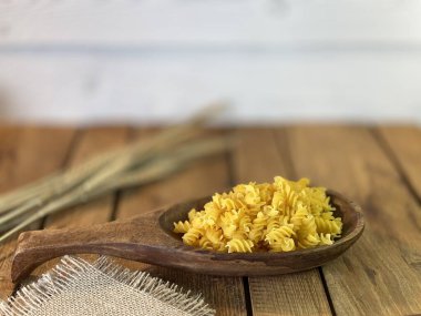 Meşe ağacından yapılmış bir masa. Üzerlerindeki kavanozları görebilirsiniz. Bir sürü mısır ve erişteli tahta kaşık.