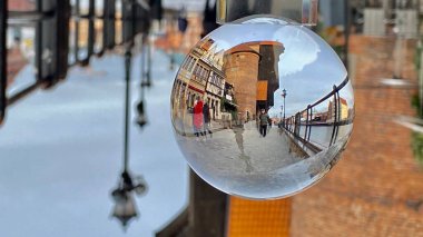 Gdansk Poland January 7, 2022. Old town historic buildings on the Motlawa River with a visible medieval crane viewed through a crystal wheel