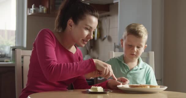 Niño Está Aprendiendo Esparcir Mantequilla Pan Con Madre Enseñándole Cocinar — Vídeos de Stock