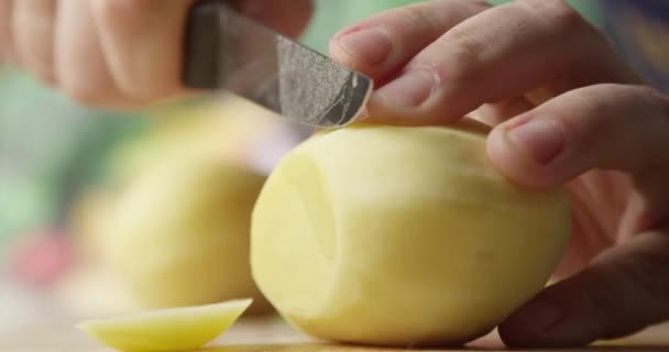 男用刀割土豆 背景上有蔬菜的特写镜头 — 图库视频影像