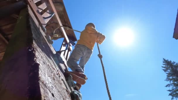 Μικρό Αγόρι Σκαρφαλώνει Στον Τοίχο Ένα Σχοινί Στην Υπαίθρια Παιδική — Αρχείο Βίντεο