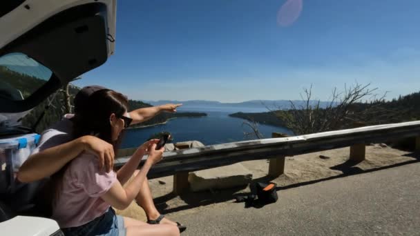 Mężczyzna Kobieta Siedzą Bagażniku Samochodu Poboczu Drogi Patrząc Telefonie Aby — Wideo stockowe