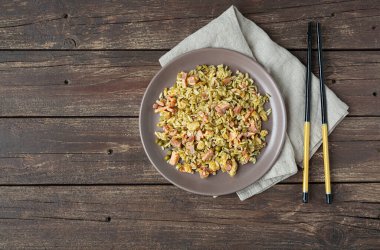 Geleneksel Çin pilavı ya da Çin pilavı. Koyu ahşap bir masada, üzerinde fotokopi alanı olan bir tabakta.