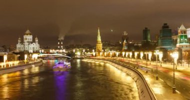 Bolşoy Moskvoretsky köprüsünden Moskova Kremlin duvarının gece görüşü. Kış. Kar yağıyor. Araba izleri. Arka planda Kurtarıcı Katedral İsa