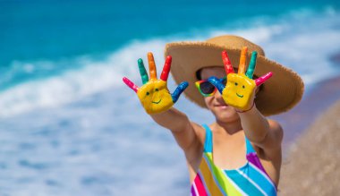 Denizde boyayla boyanmış çocuk elleri. Seçici odaklanma. Çocuk.