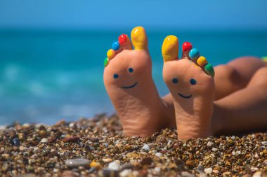 Denizdeki boyalarla boyanmış çocuk ayakları. Seçici odaklanma. Çocuk.