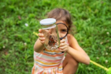 Çocuk doğada kelebekler yakalıyor. Seçici odaklanma. Doğa.,