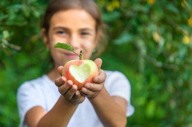 Çocuk bahçede bir elma yiyor. Seçici odaklanma. Çocuk.