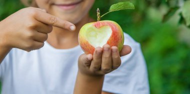 Çocuk bahçede bir elma yiyor. Seçici odaklanma. Çocuk.