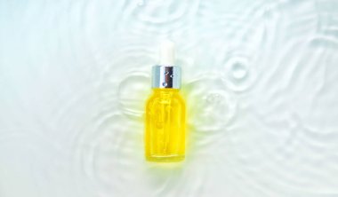 Suyun içindeki bir şişede kozmetik ürünler, cilt suyu konsepti. Hyaluronik asit. Seçici odaklanma. Doğa.