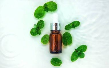 Suyun içindeki bir şişede kozmetik ürünler, cilt suyu konsepti. Seçici odaklanma. Doğa.