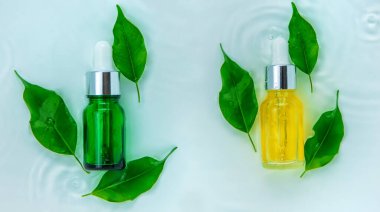 Suyun içindeki bir şişede kozmetik ürünler, cilt suyu konsepti. Seçici odaklanma. Doğa.