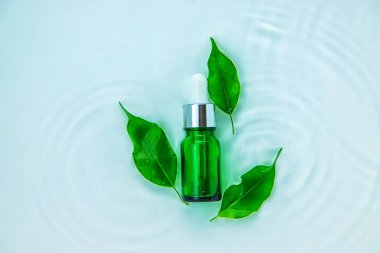 Suyun içindeki bir şişede kozmetik ürünler, cilt suyu konsepti. Seçici odaklanma. Doğa.