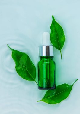 Suyun içindeki bir şişede kozmetik ürünler, cilt suyu konsepti. Seçici odaklanma. Doğa.