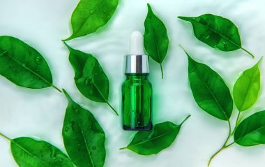 Suyun içindeki bir şişede kozmetik ürünler, cilt suyu konsepti. Seçici odaklanma. Doğa.