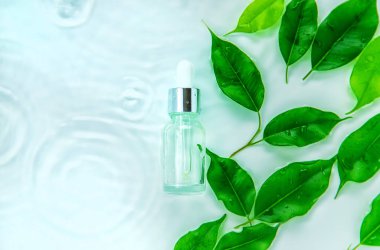 Suyun içindeki bir şişede kozmetik ürünler, cilt suyu konsepti. Seçici odaklanma. Doğa.