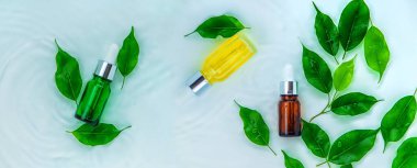 Suyun içindeki bir şişede kozmetik ürünler, cilt suyu konsepti. Seçici odaklanma. Doğa.