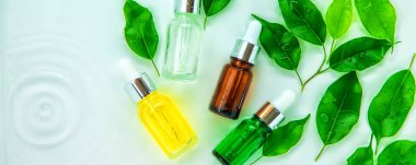 Suyun içindeki bir şişede kozmetik ürünler, cilt suyu konsepti. Seçici odaklanma. Doğa.