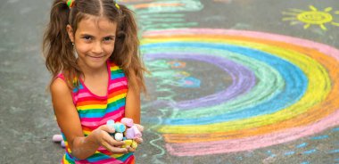 Çocuk asfalta tebeşirle çizer. Seçici odaklanma. Çocuk.