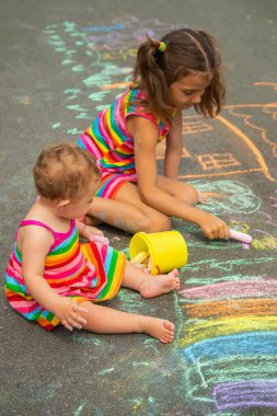 Çocuk asfalta tebeşirle çizer. Seçici odaklanma. Çocuk.