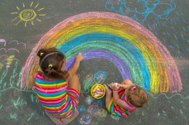 Çocuk asfalta tebeşirle çizer. Seçici odaklanma. Çocuk.