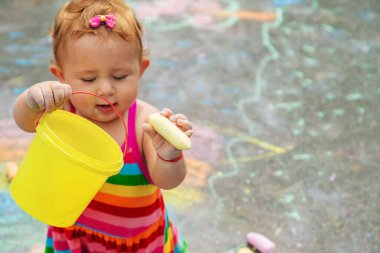 Çocuk asfalta tebeşirle çizer. Seçici odaklanma. Çocuk.