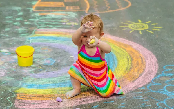 아이는 아스팔트에 분필로 그림을 그립니다 선택적 집중입니다 어린이 — 스톡 사진