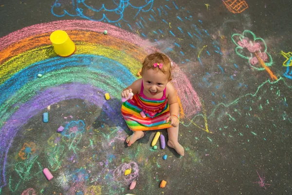 아이는 아스팔트에 분필로 그림을 그립니다 선택적 집중입니다 어린이 — 스톡 사진