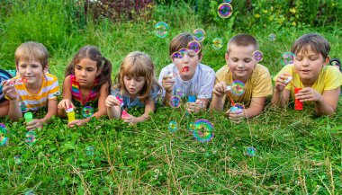 Çocuklar sokakta baloncuk çıkarıyor. Seçici odaklanma. Doğa.