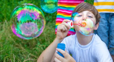 Çocuklar sokakta baloncuk çıkarıyor. Seçici odaklanma. Doğa.