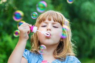 Çocuklar sokakta baloncuk çıkarıyor. Seçici odaklanma. Doğa.