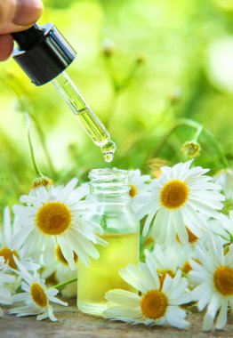 Papatya yağı küçük bir şişede. Seçici odaklanma. Doğa.