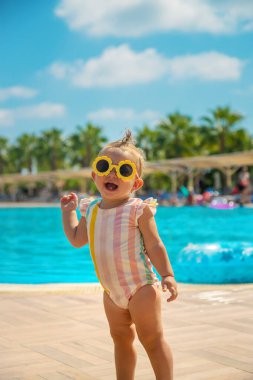 Havuz kenarında güneş gözlüklü bir çocuk. Seçici odaklanma. Seyahat.