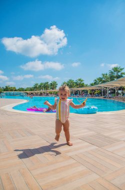 Havuz kenarında güneş gözlüklü bir çocuk. Seçici odaklanma. Seyahat.