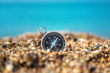 Deniz kıyısındaki pusula. Seçici odaklanma. Seyahat.