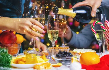 Şampanya, Noel ağacının arka planında. - İnsanlar. Seçici odaklanma. Tatil.
