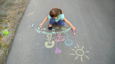 Çocuk asfta bir aile çiziyor. Seçici odaklanma. Çocuk.