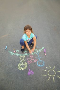 Çocuk asfta bir aile çiziyor. Seçici odaklanma. Çocuk.