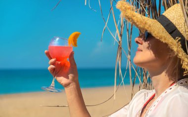 Kumsalda elinde kokteyl tutan bir kadın. Seçici odaklanma. İç..