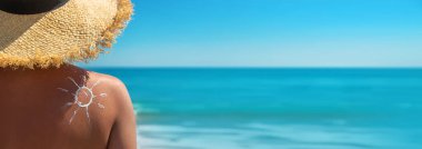 Sırtında güneş kremi olan bir kadın. Seçici odaklanma. Deniz.